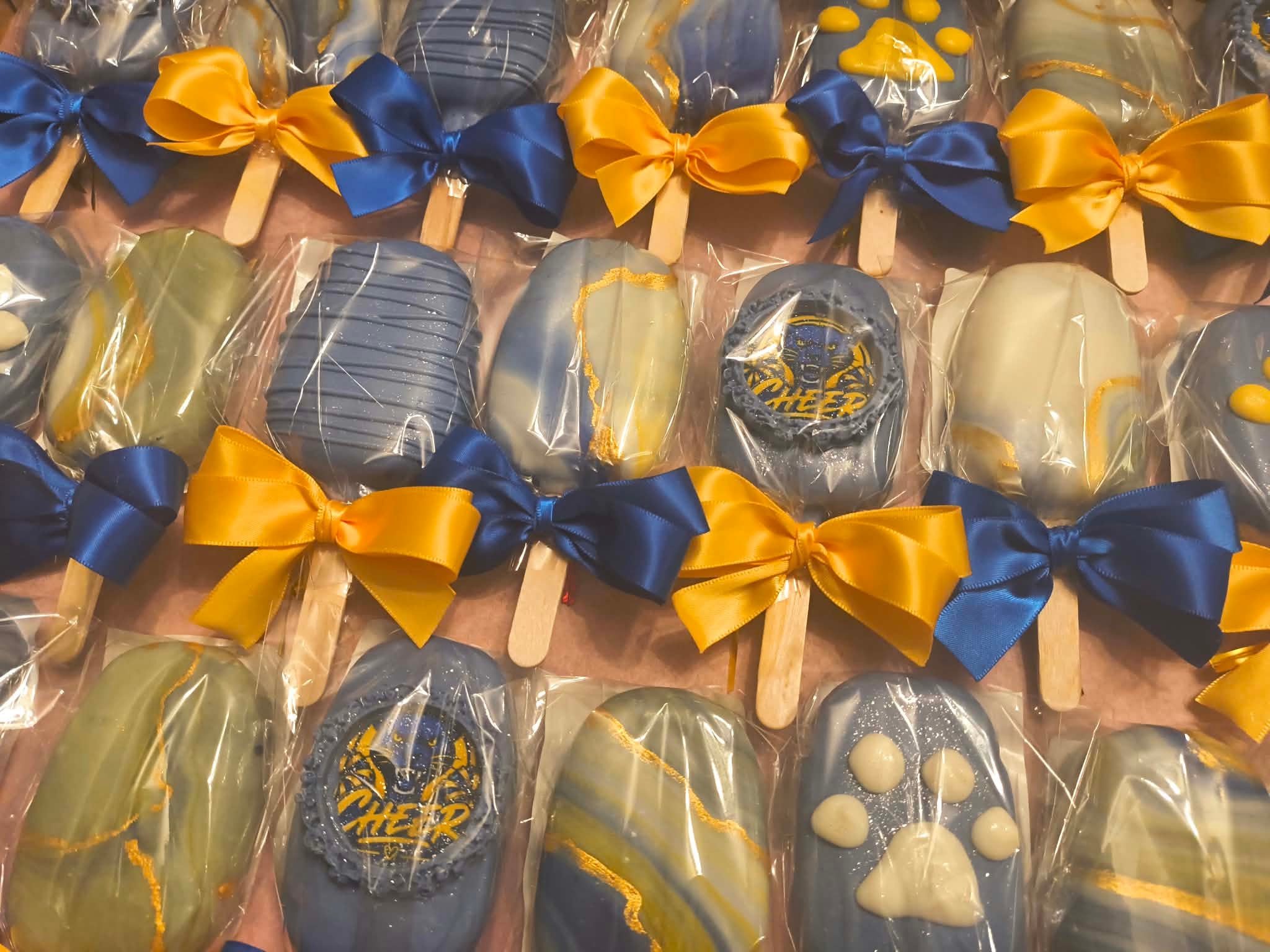 Decorated chocolate lollipops with blue and gold bows
