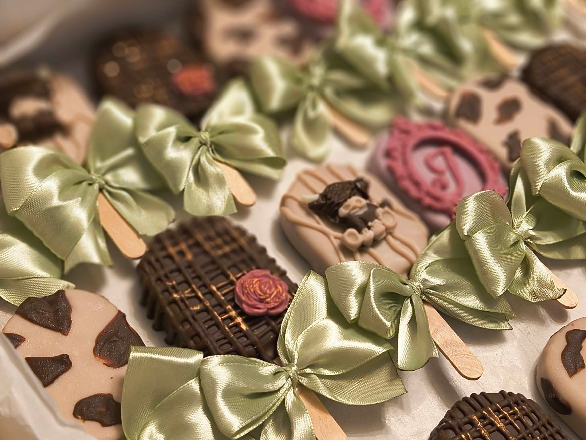 Decorated chocolates with green ribbon bows