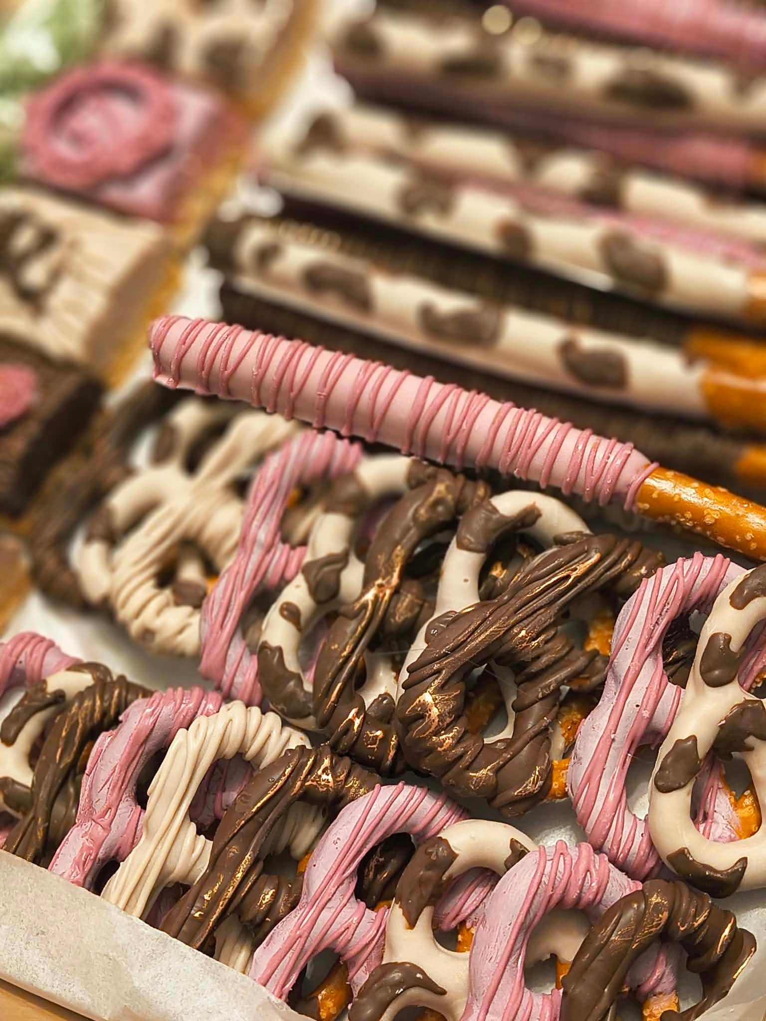 Chocolate covered pretzel rods with pink ribbons