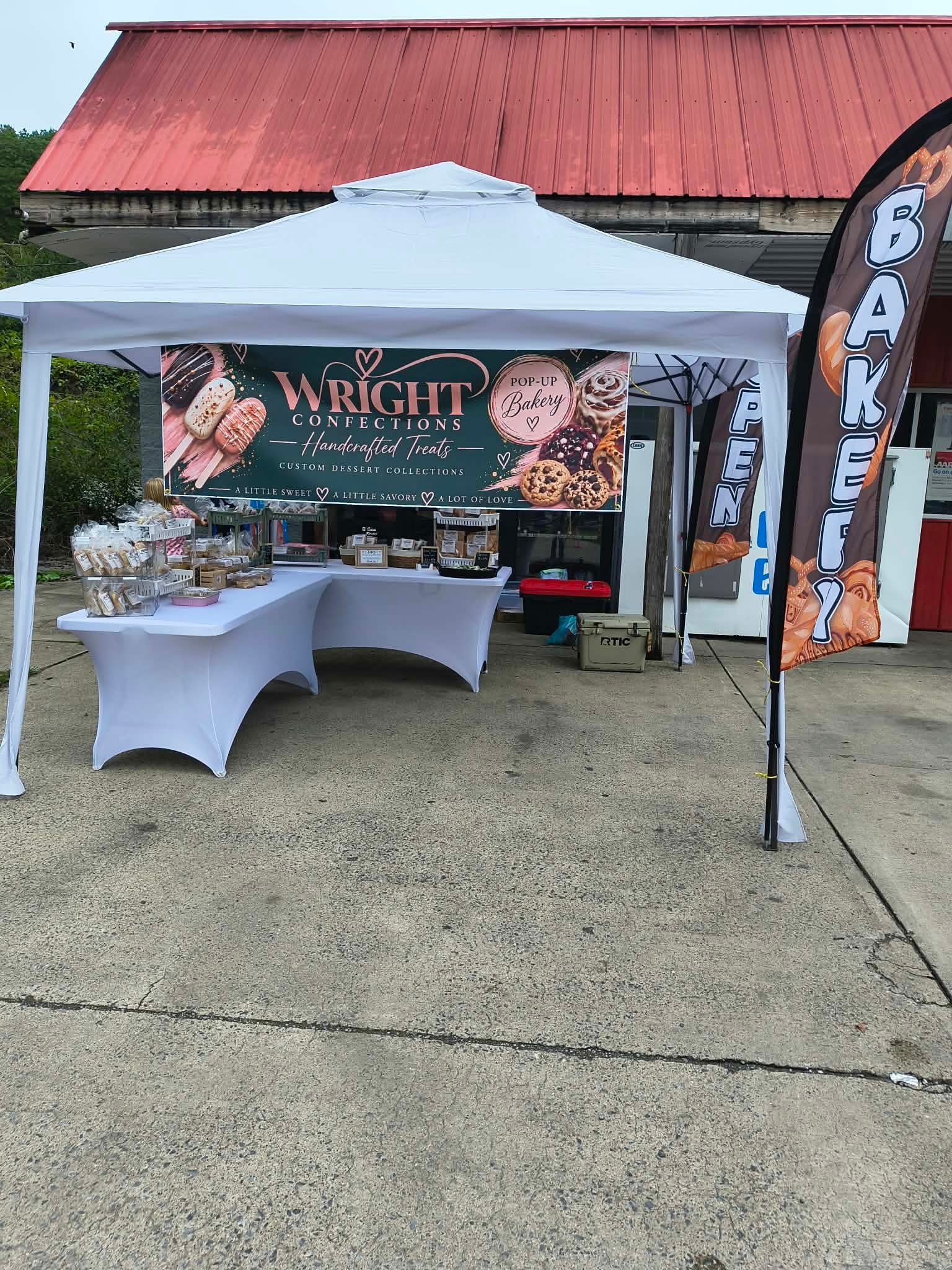 Wright Confections pop-up bakery booth setup with banner and product display